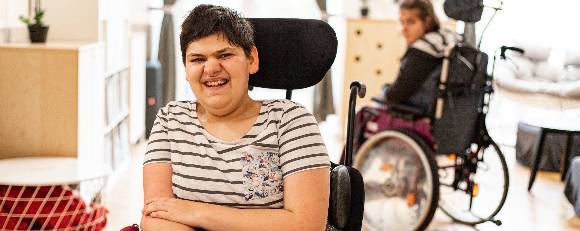 Eine junge Frau im Rollstuhl lacht