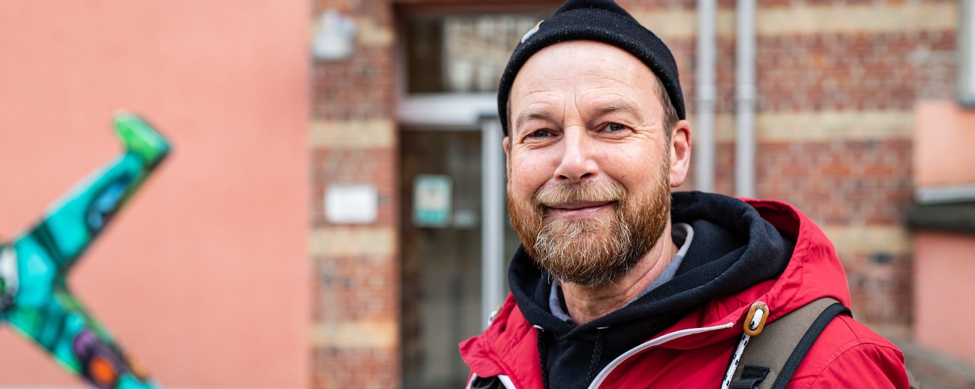 Sympathischer Mann mit Rucksack ist ein Mitarbeiter