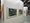 Zwei farbenfrohe, abstrakte Gemälde in weißen Rahmen hängen nebeneinander an einer weißen Wand in einer Galerie. Links ist ein weiteres buntes Kunstwerk teilweise sichtbar. Im Hintergrund erstreckt sich der Ausstellungsraum mit weiteren weißen Wänden.