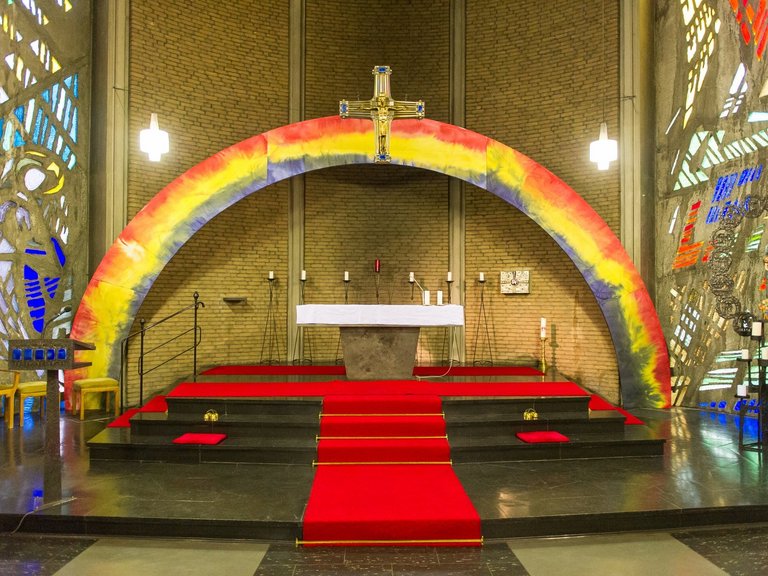 Farbenfrohe Kirche: der Bereich hinter dem Altar ist mit einem großen bunten Regenbogen aus Pappe geschmückt
