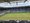 Das Bild zeigt das leere Fußballstadion Borussia-Park. Auf den blauen Tribünenstühlen ist mit weißen Sitzen der Schriftzug „BORUSSIA“ sowie zwei Vereinslogos angeordnet. Im Vordergrund liegt das grüne Spielfeld. Am Dachrand ist ein Banner mit der Aufschrift „GEGEN RASSISMUS“ zu erkennen.