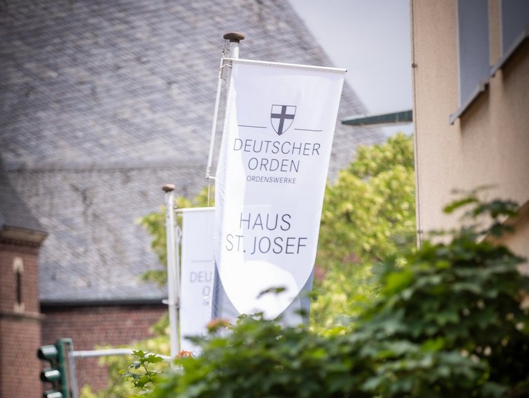 Auf dem Foto ist die Fahne des Haus St. Josef mit dem Ordenswerke Logo zu sehen