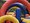 Ein großes, buntes Aufblas-Spielgerät mit roten und blauen Bögen, auf dem Kinder im Freien spielen.